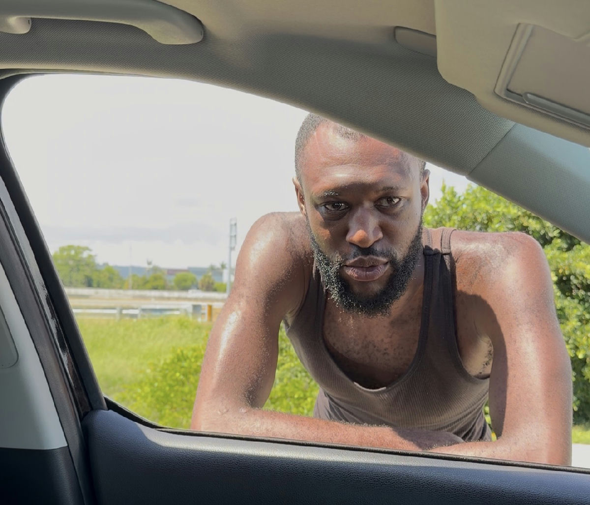 A man leaning into a car window during a Fresh Start street outreach conversation about addiction treatment